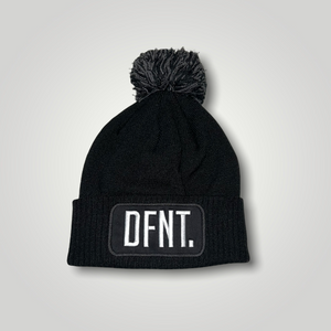 A black beanie hat with a two tone black and white bobble on top. The hat is branded with DFNT. embroidered on the centre patch in white. It is soft to the touch and has a double layer knit and ribbed cuff.