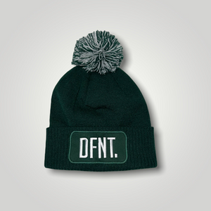 A bottle green beanie hat with a two tone green and white bobble on top. The hat is branded with DFNT. embroidered on the centre patch in white. It is soft to the touch and has a double layer knit and ribbed cuff.
